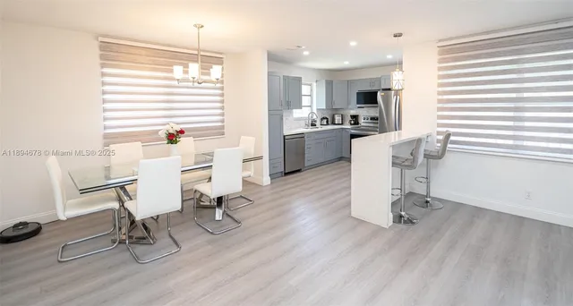 a kitchen with a sink a window a dining table and chairs