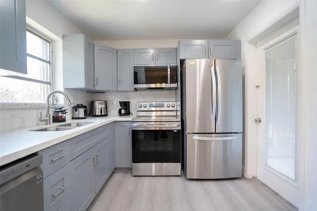 a kitchen with stainless steel appliances a refrigerator sink and microwave