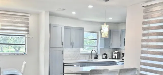 a kitchen with granite countertop white cabinets and window