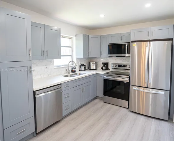 a kitchen with a refrigerator sink and wooden floor