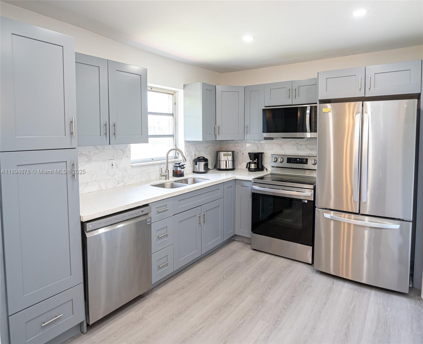 5300 Washington Street, Unit T227 Hollywood, FL 33021 - Photo 26 of 45 a kitchen with a refrigerator sink and wooden floor