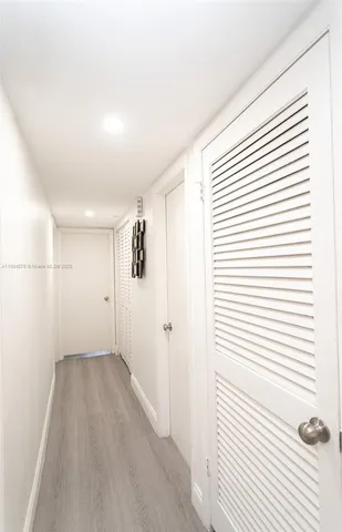 a view of a room with wooden floor and white walls