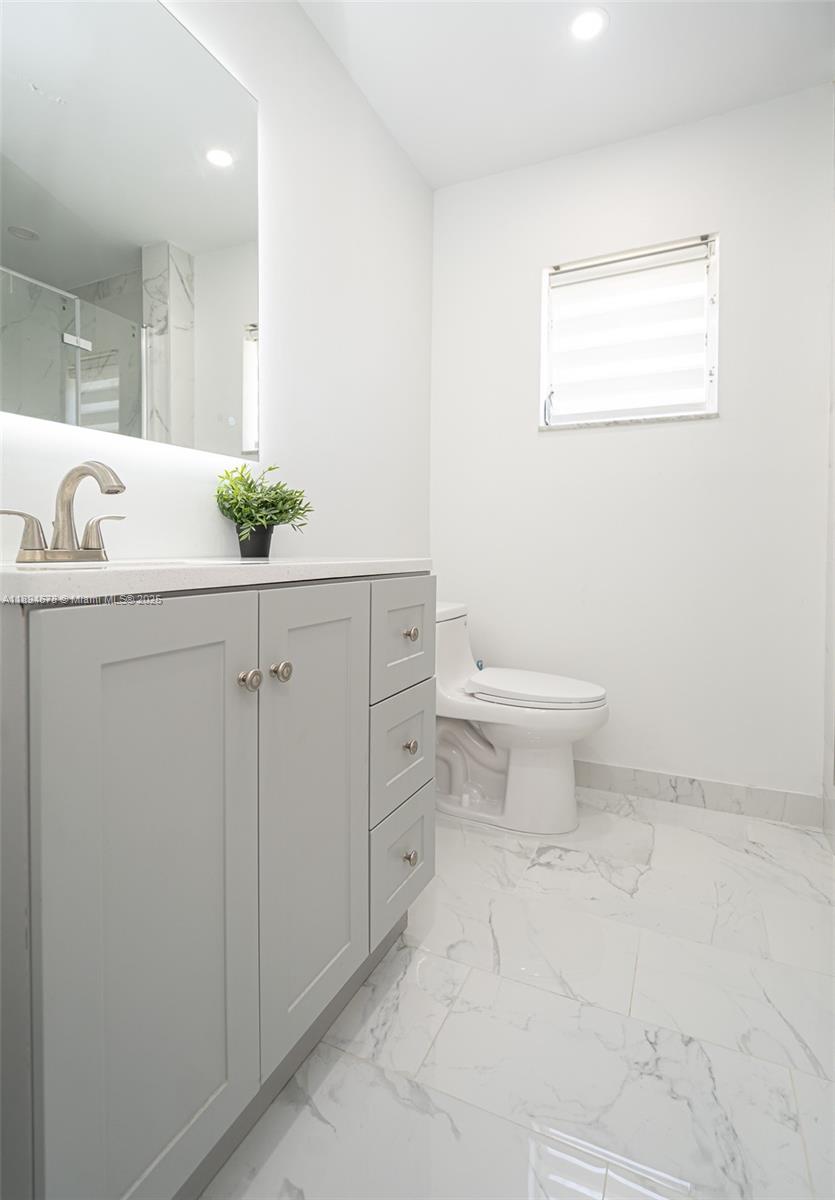 5300 Washington Street, Unit T227 Hollywood, FL 33021 - Photo 34 of 45 a bathroom with a sink a toilet and mirror