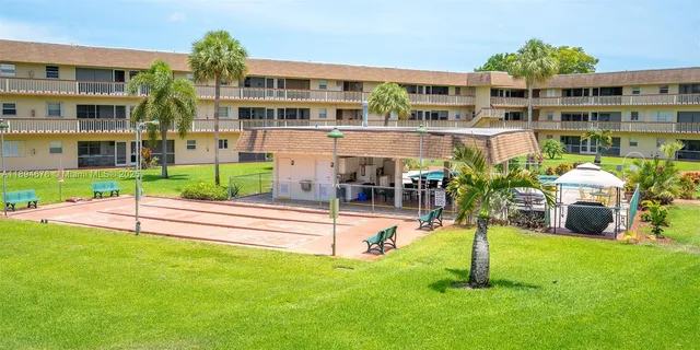a view of building with a garden and plants