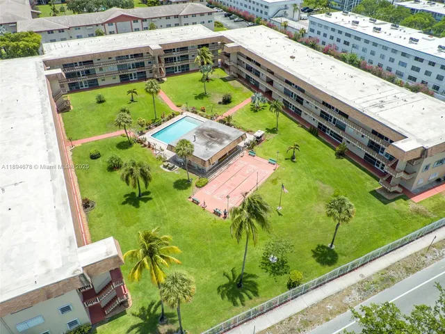 an aerial view of a swimming pool with a garden and trees