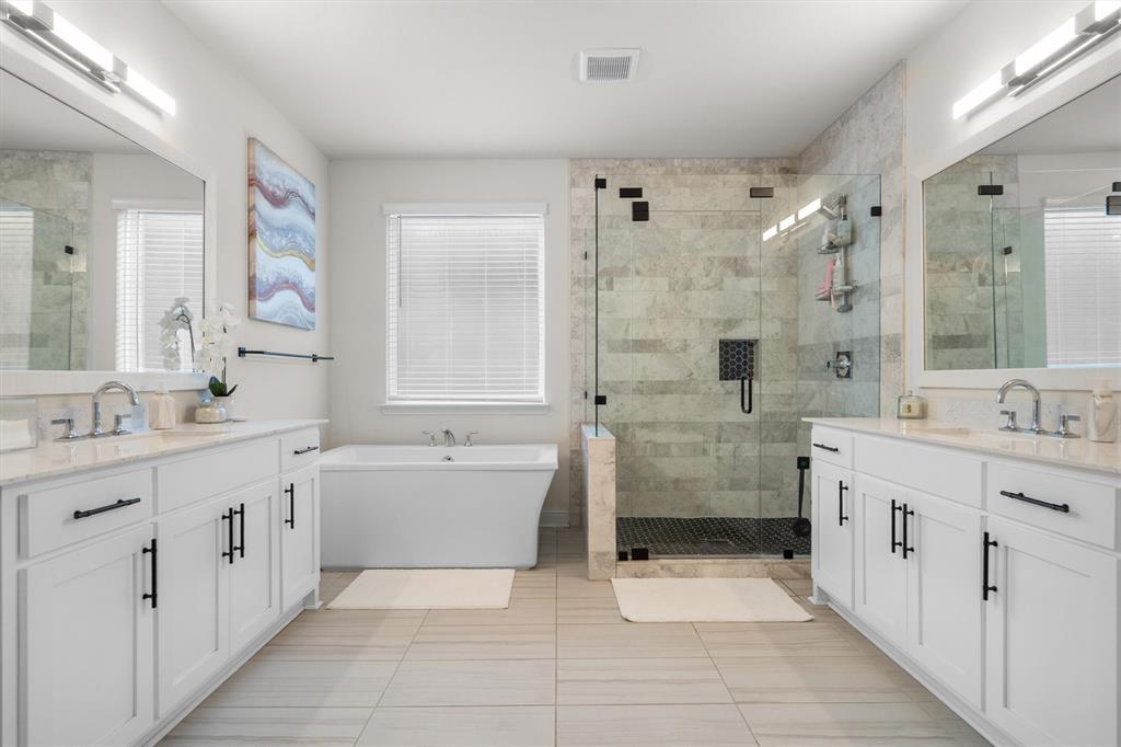 1308 Redbrick Lane Northlake, TX 76247 - Photo 22 of 40 a bathroom with a double vanity sink a large mirror and a bathtub
