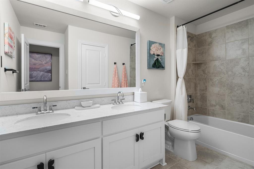 1308 Redbrick Lane Northlake, TX 76247 - Photo 32 of 40 a bathroom with a double vanity sink toilet mirror and bathtub