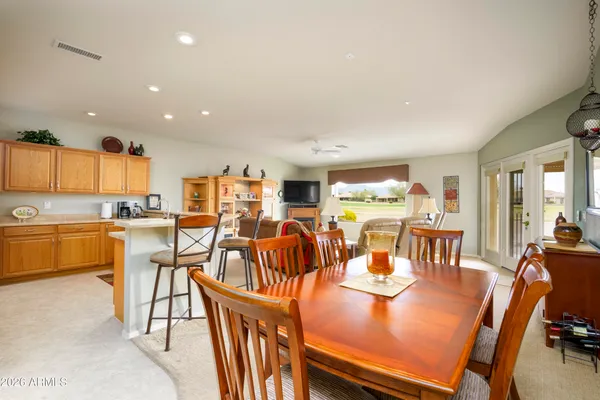 a view of a dining room and livingroom with furniture a rug a kitchen and a chandelier
