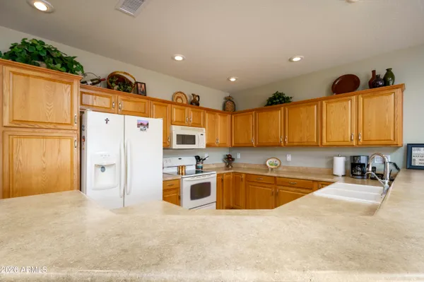 a kitchen with granite countertop a refrigerator a sink a stove and cabinets