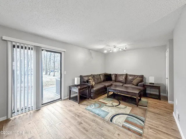 a living room with furniture a chandelier and a dining table
