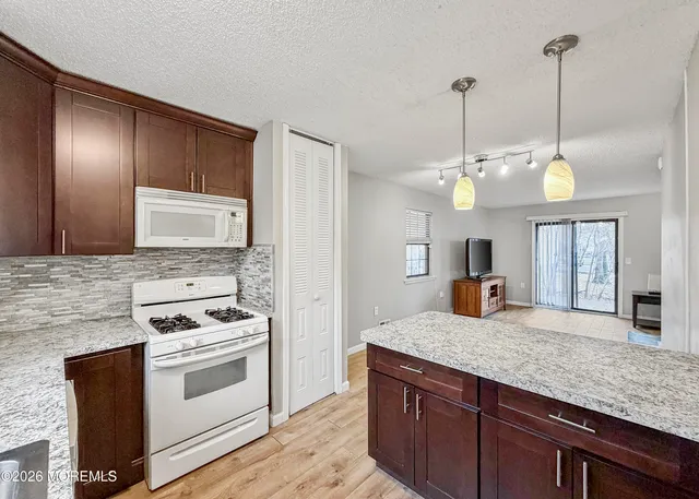a kitchen with stainless steel appliances granite countertop a stove a sink and a microwave