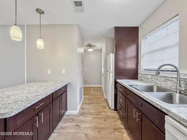 a kitchen with kitchen island granite countertop wooden cabinets and a granite counter tops