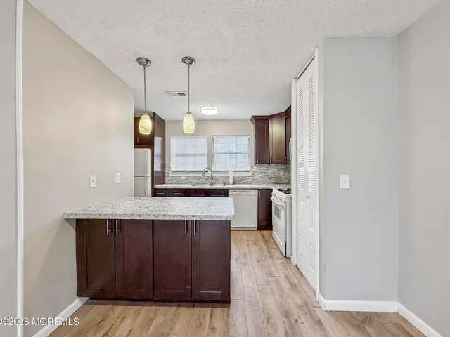 a large kitchen with kitchen island a stove a sink dishwasher and a oven