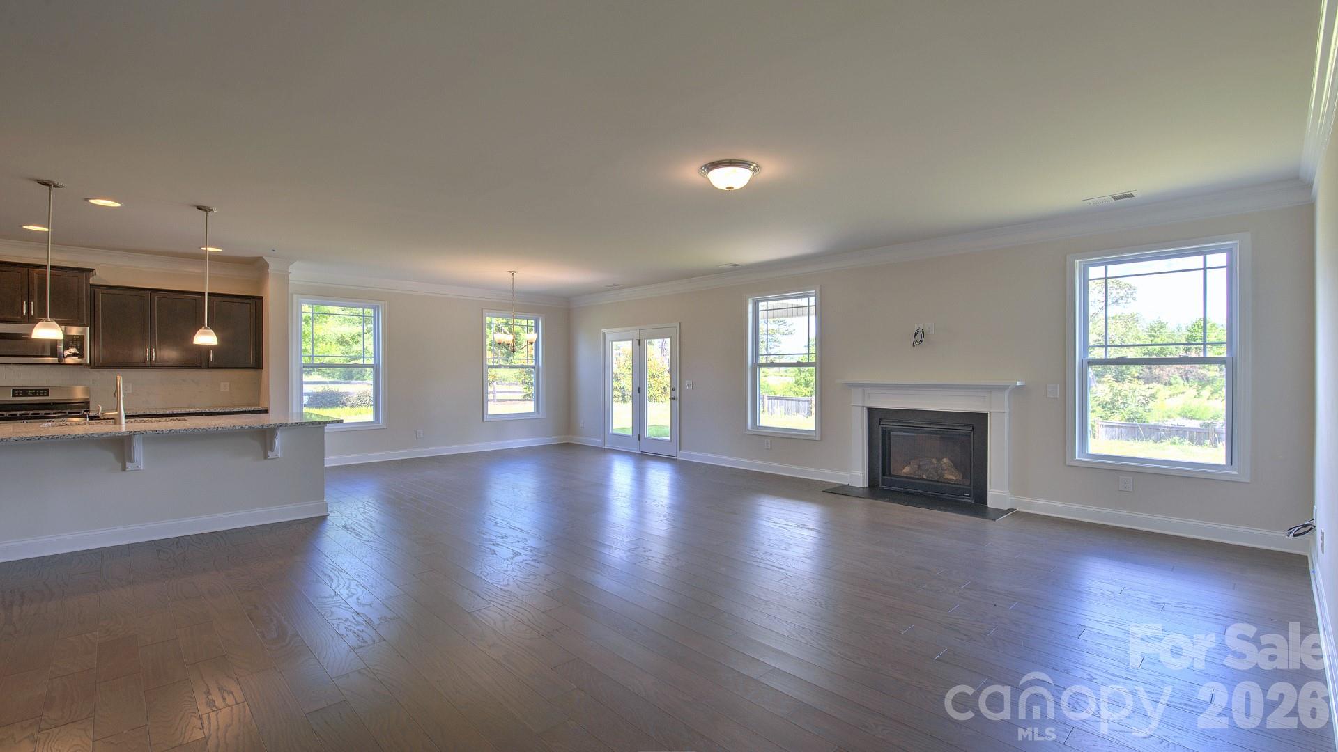 505 River Btm Road Fletcher, NC 28732 - Photo 12 of 20 an empty room with wooden floor and fireplace