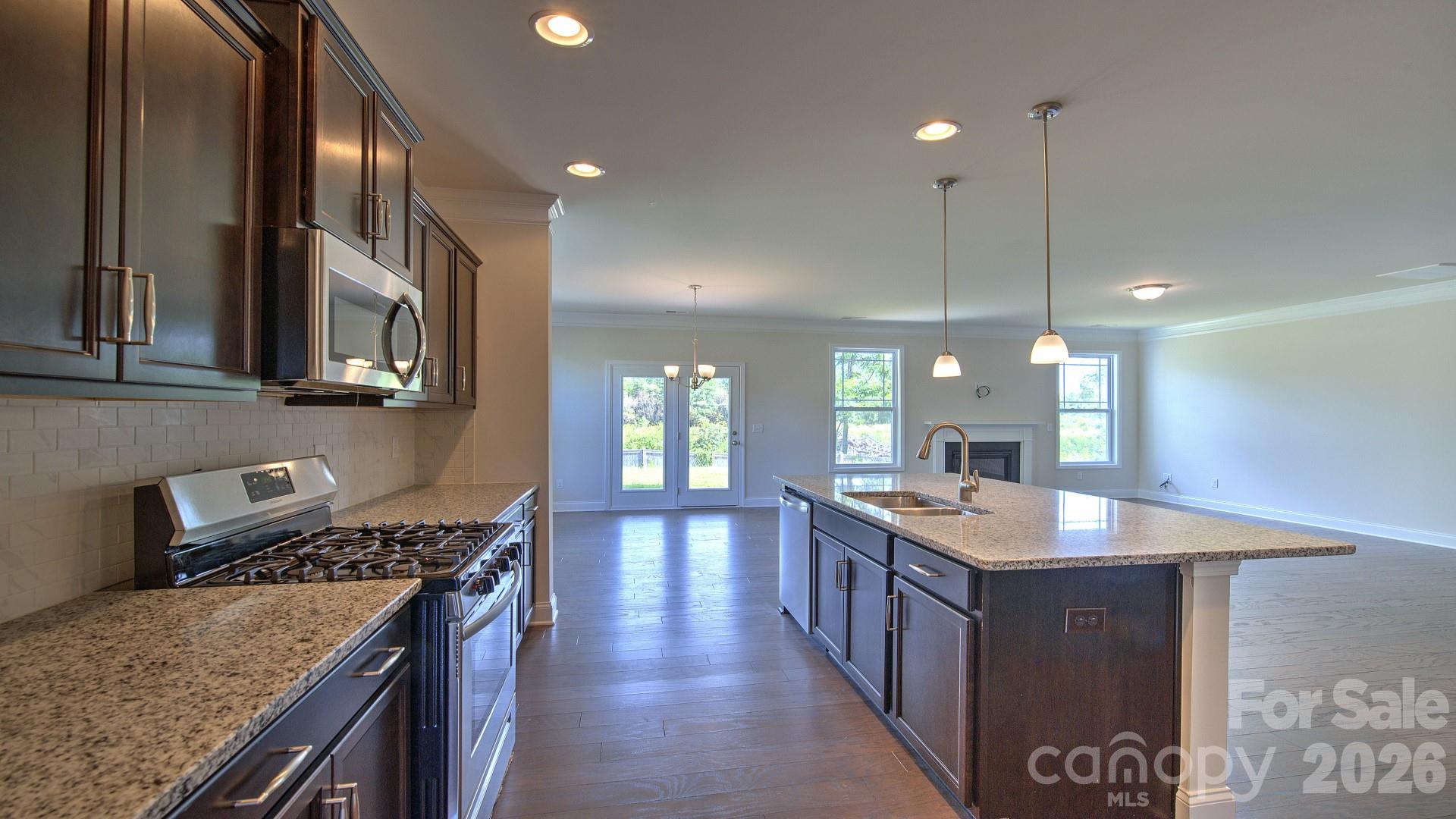 505 River Btm Road Fletcher, NC 28732 - Photo 10 of 20 a kitchen with stainless steel appliances granite countertop a sink a stove and a wooden floor