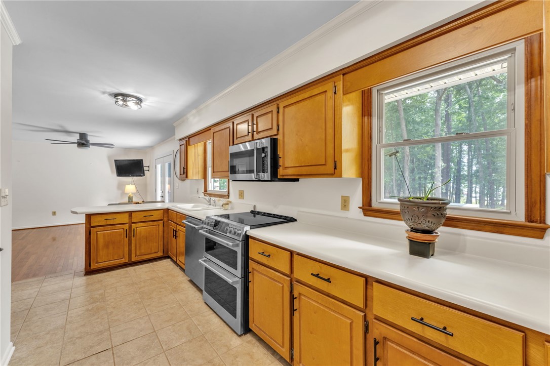 4416 Denver Cove Road Anderson, SC 29625 - Photo 11 of 31 A well-lit kitchen boasts ample counter space, rich wood cabinetry, and a double oven for culinary adventures.