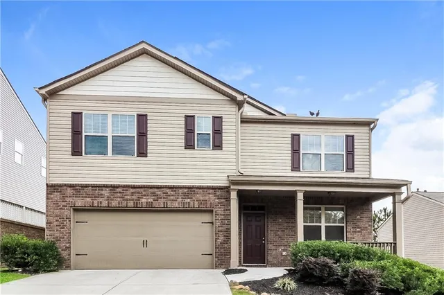 a view of a house with large windows and a yard