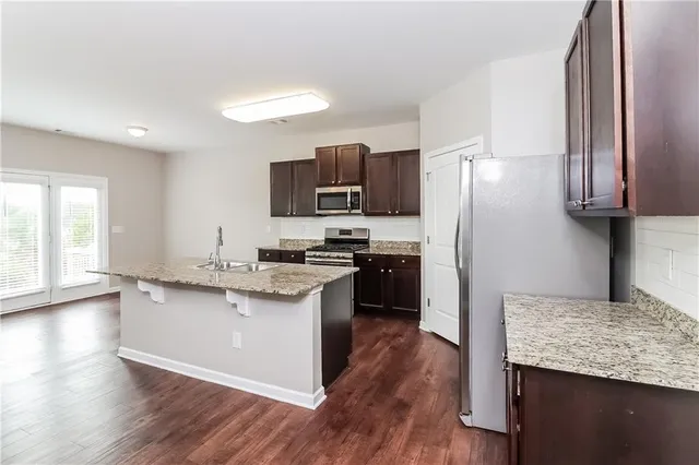 a kitchen with granite countertop a refrigerator stove top oven and sink