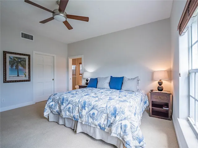 a bedroom with a bed and ceiling fan