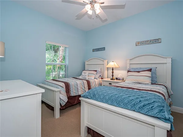 a bedroom with two beds and a chandelier