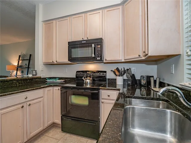 a kitchen with granite countertop white cabinets and stainless steel appliances