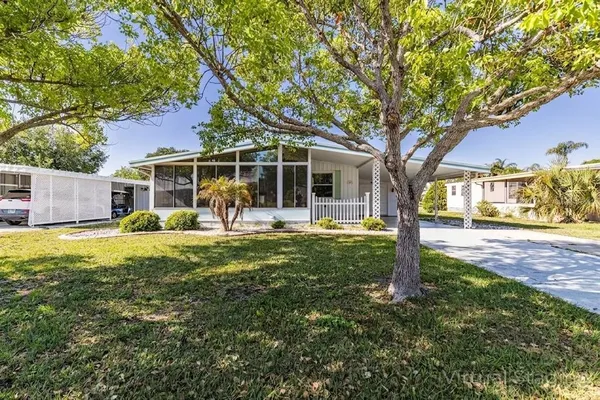 a view of a house with backyard and a tree