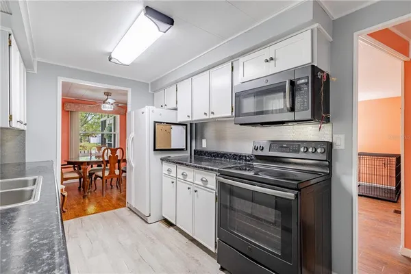 a kitchen with stainless steel appliances a stove microwave and sink