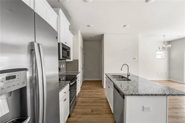 a kitchen with stainless steel appliances granite countertop a stove a sink and a refrigerator