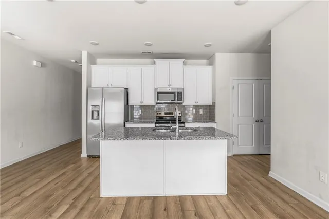 a kitchen with stainless steel appliances granite countertop a sink stove and microwave