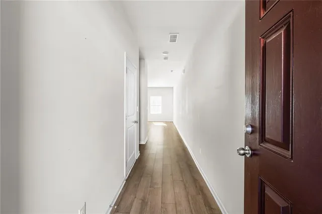 a view of a hallway with wooden floor and staircase