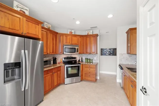 a kitchen with granite countertop a sink appliances and cabinets