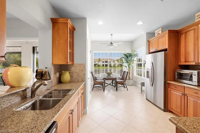 a kitchen with stainless steel appliances granite countertop a stove top oven a sink dishwasher a dining table and chairs with wooden floor