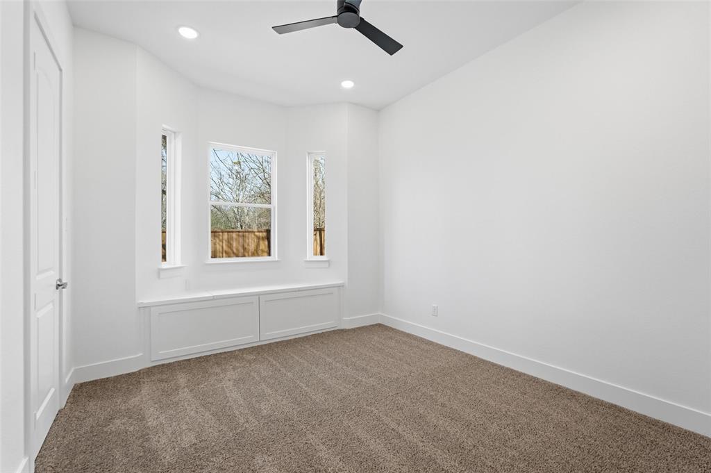 1110 Norris Street Commerce, TX 75428 - Photo 12 of 40 an empty room with a window and a ceiling fan