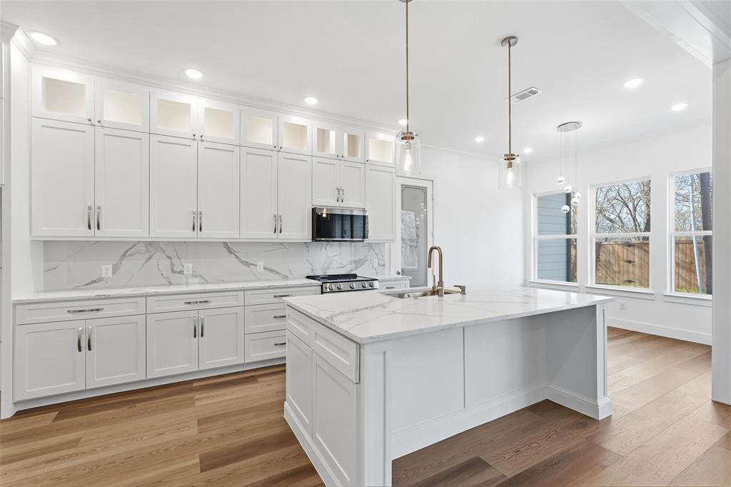 1110 Norris Street Commerce, TX 75428 - Photo 21 of 40 a kitchen with kitchen island white cabinets and white appliances