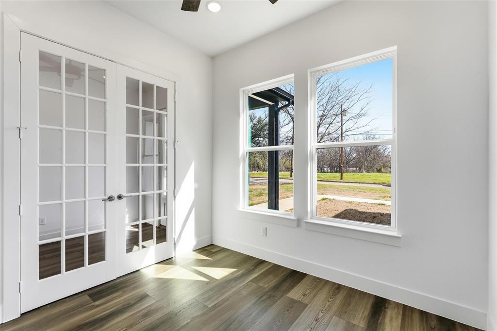 1110 Norris Street Commerce, TX 75428 - Photo 4 of 40 a view of an empty room with wooden floor and windows