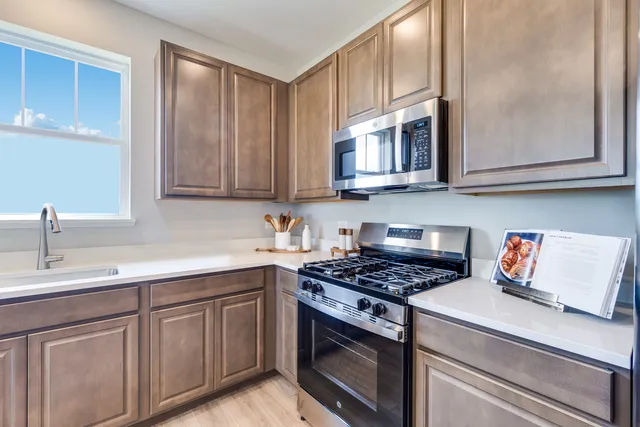 a kitchen with stainless steel appliances granite countertop a sink stove and cabinets