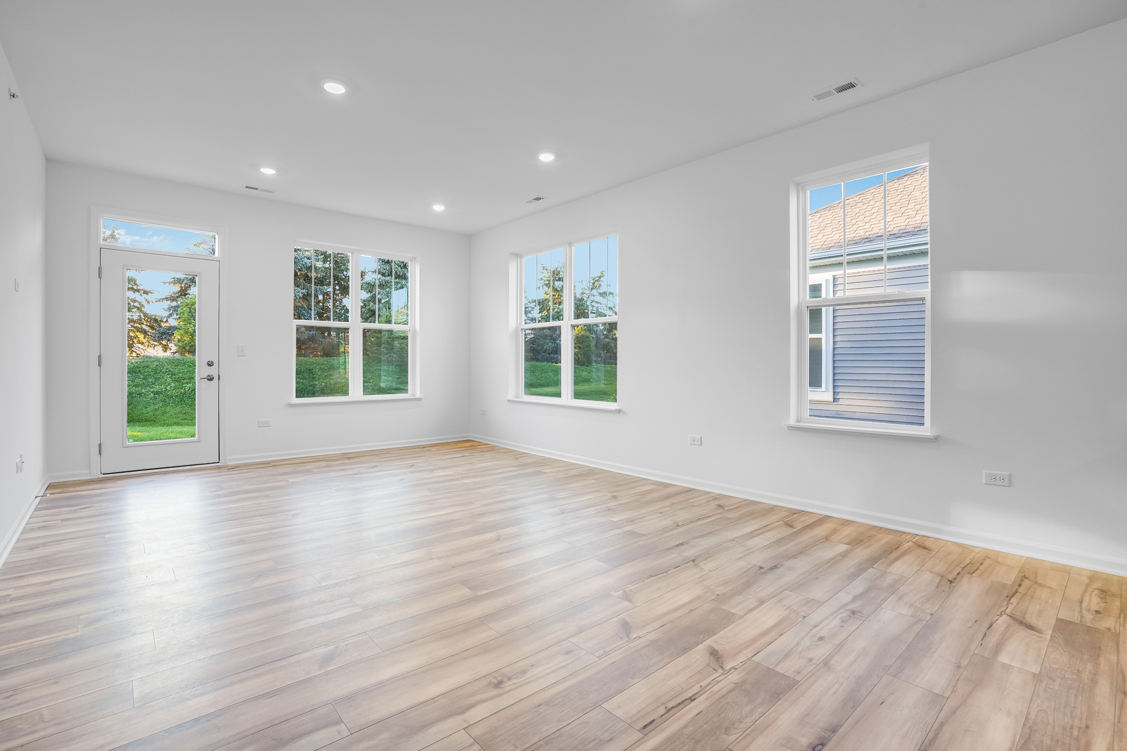 12241 Barcroft Circle Huntley, IL 60142 - Photo 5 of 38 a view of an empty room with wooden floor and a window
