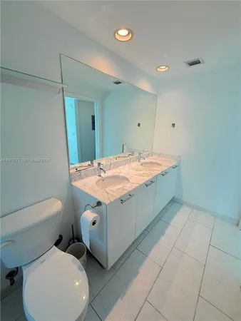 a bathroom with a sink a toilet and mirror