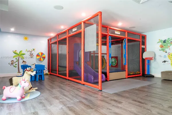 a utility room with stainless steel appliances wooden floor and a view of living room
