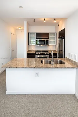 a large kitchen with stainless steel appliances granite countertop a stove and a sink