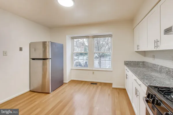 wooden floor in an empty room with a kitchen