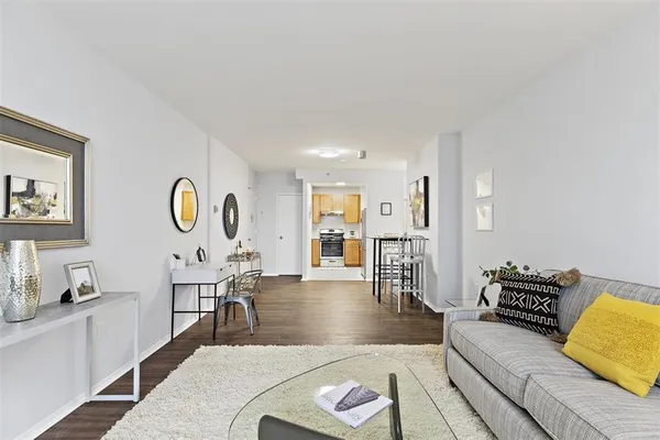a living room with furniture a wooden floor and next to a window