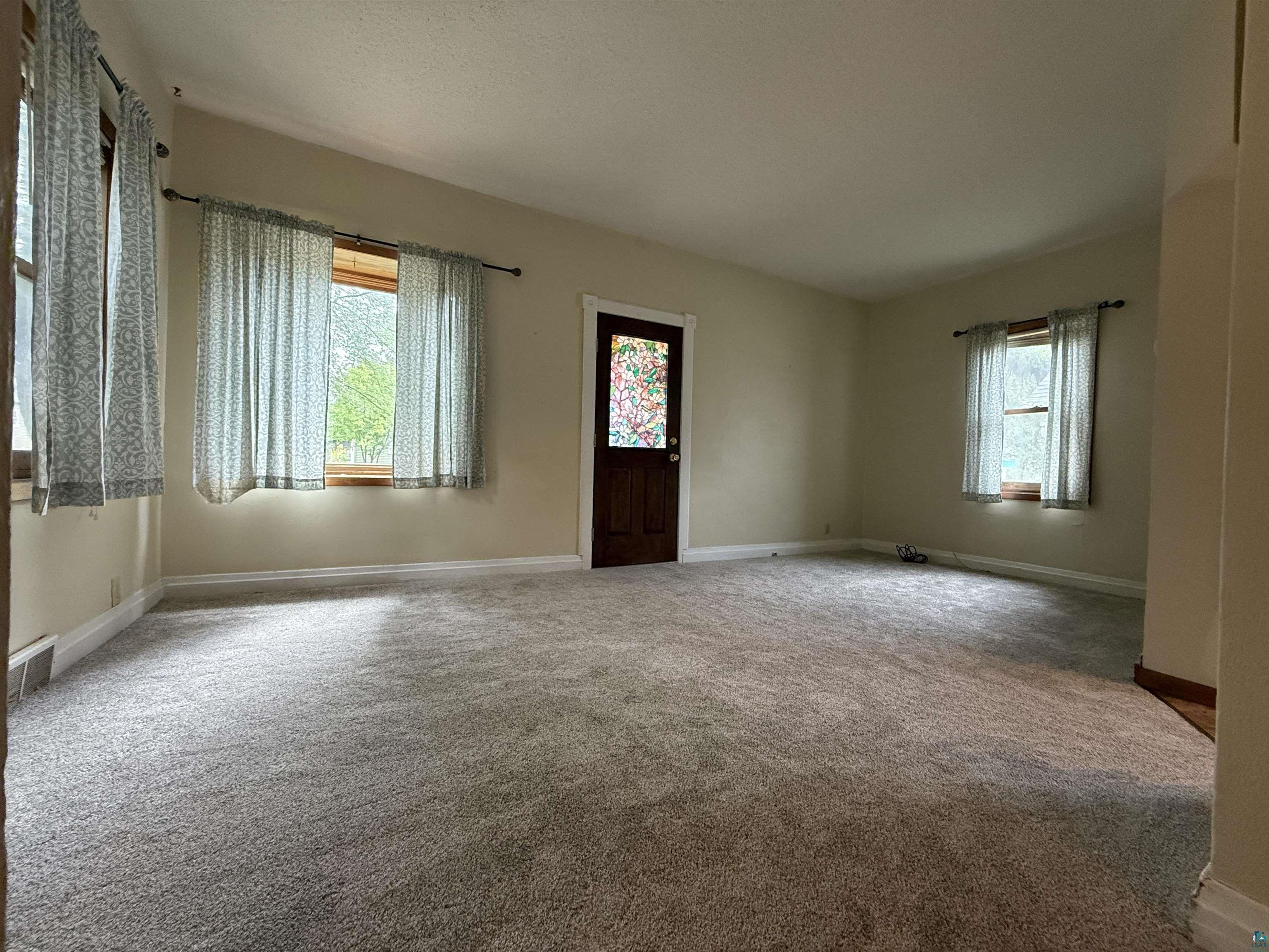 809 16th Street North Virginia, MN 55792 - Photo 13 of 44 Unfurnished living room featuring carpet flooring and baseboards