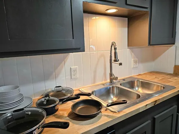 a kitchen with granite countertop a sink stove and refrigerator