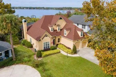 an aerial view of a house with a garden and lake view