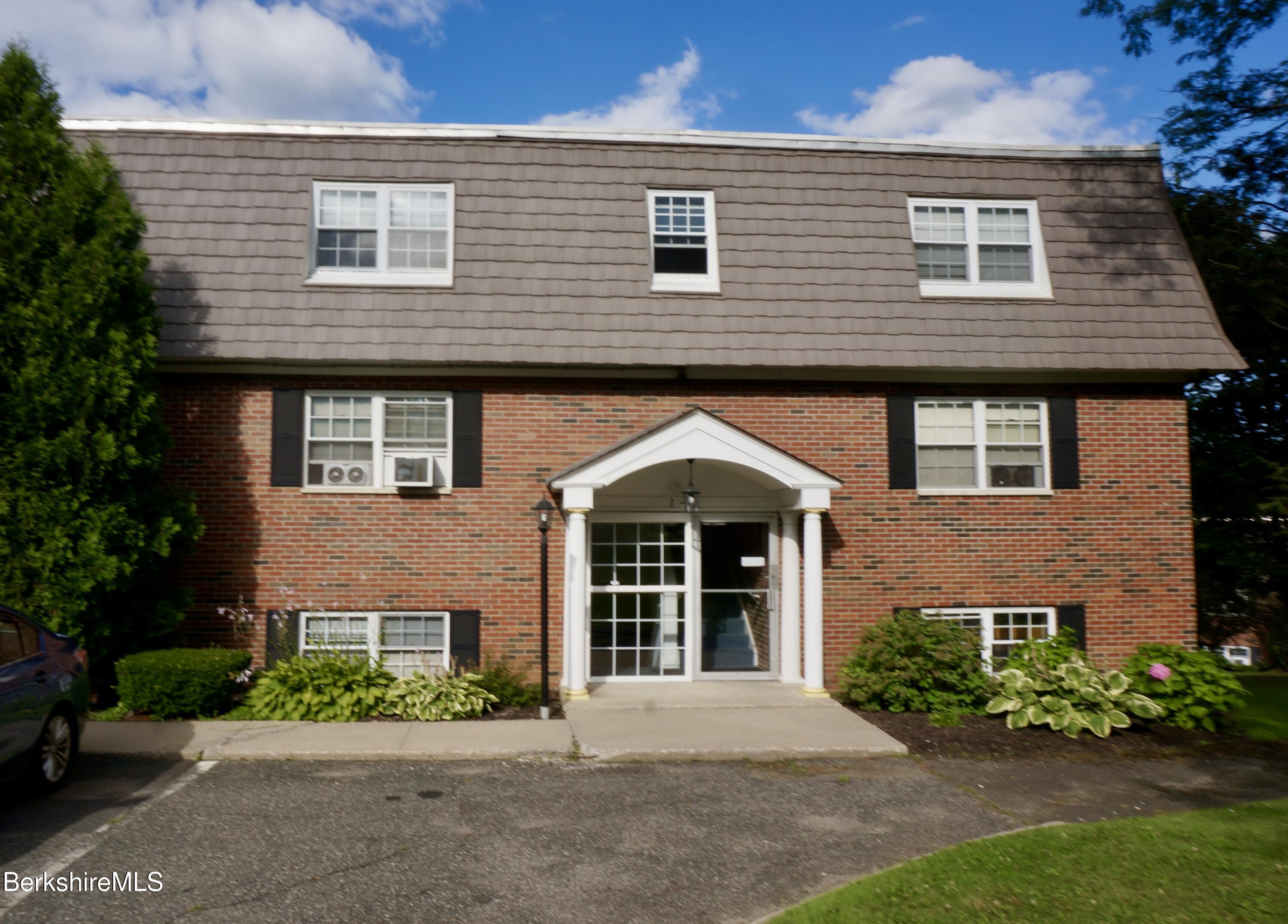a front view of a house with a garden and plants