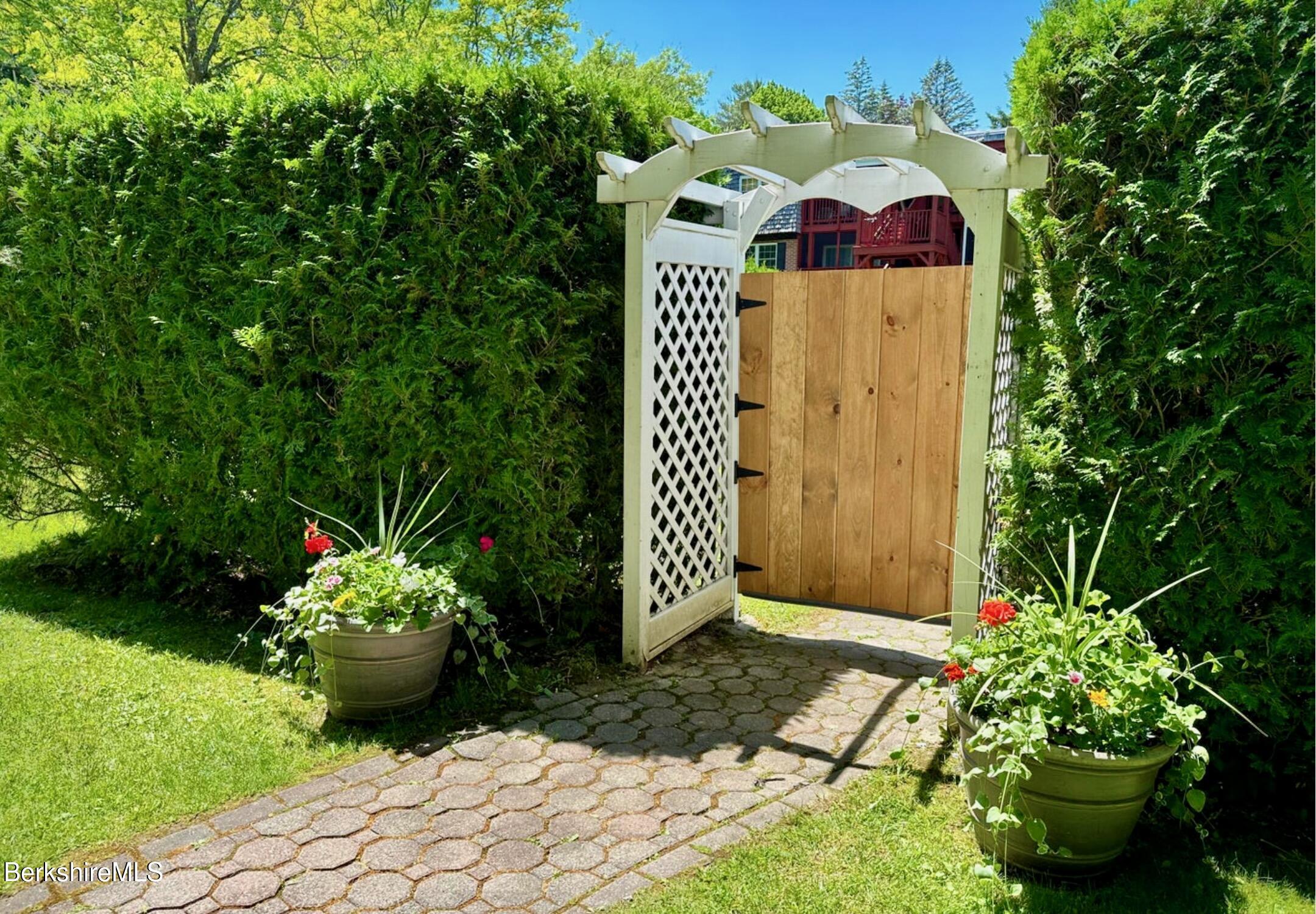260 Pittsfield Road, Unit B5 Lenox, MA 01240 - Photo 11 of 13 a front view of a house with a yard and garden