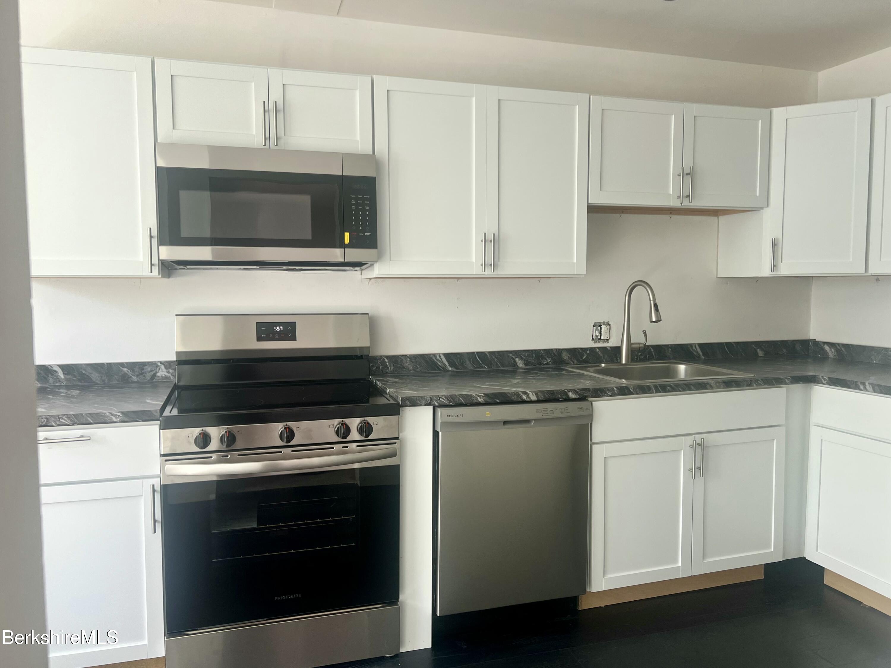 260 Pittsfield Road, Unit B5 Lenox, MA 01240 - Photo 2 of 13 a kitchen with stainless steel appliances granite countertop a stove microwave and sink