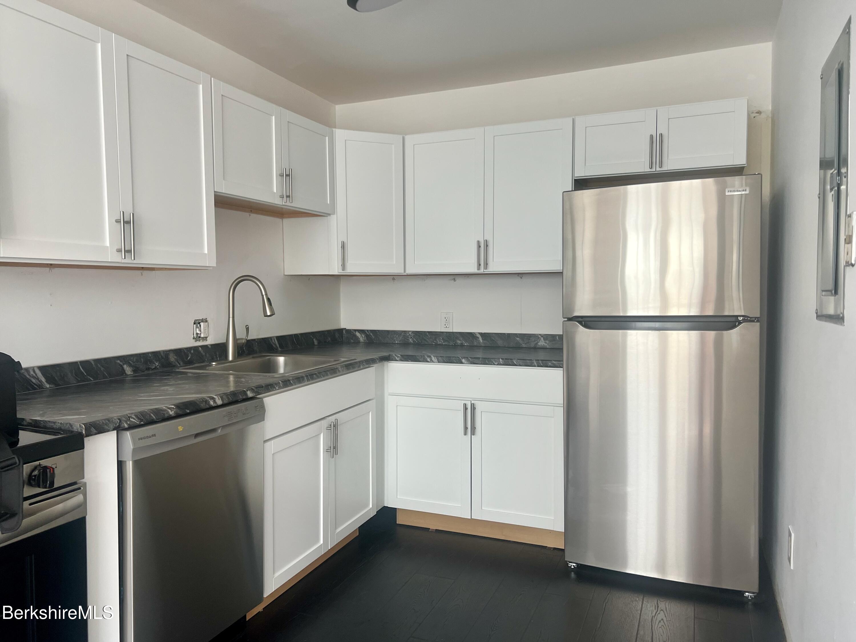 260 Pittsfield Road, Unit B5 Lenox, MA 01240 - Photo 3 of 13 a kitchen with a refrigerator sink and cabinets