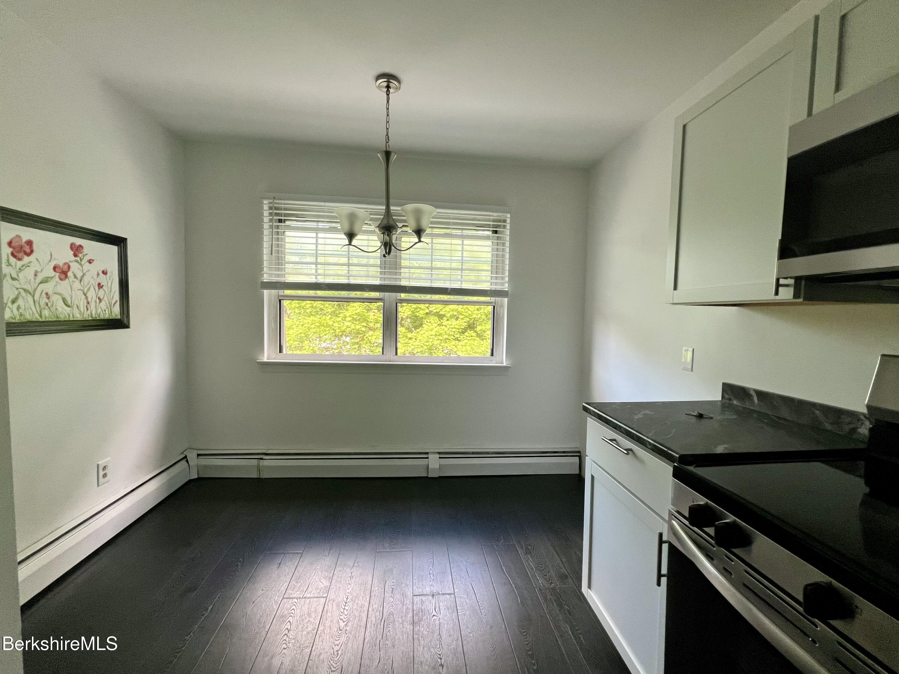 260 Pittsfield Road, Unit B5 Lenox, MA 01240 - Photo 4 of 13 a kitchen with a stove and a wooden floor